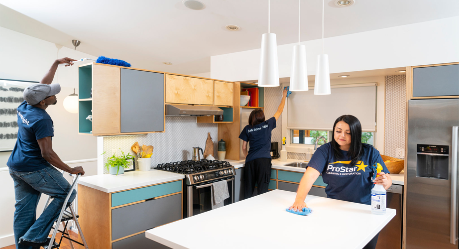 Multiple cleaners cleaning kitchen